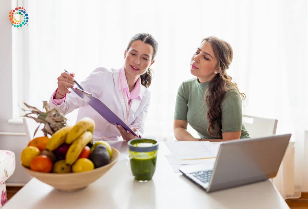 Dietitian consulting with patient with a bowl of fruit in the foreground