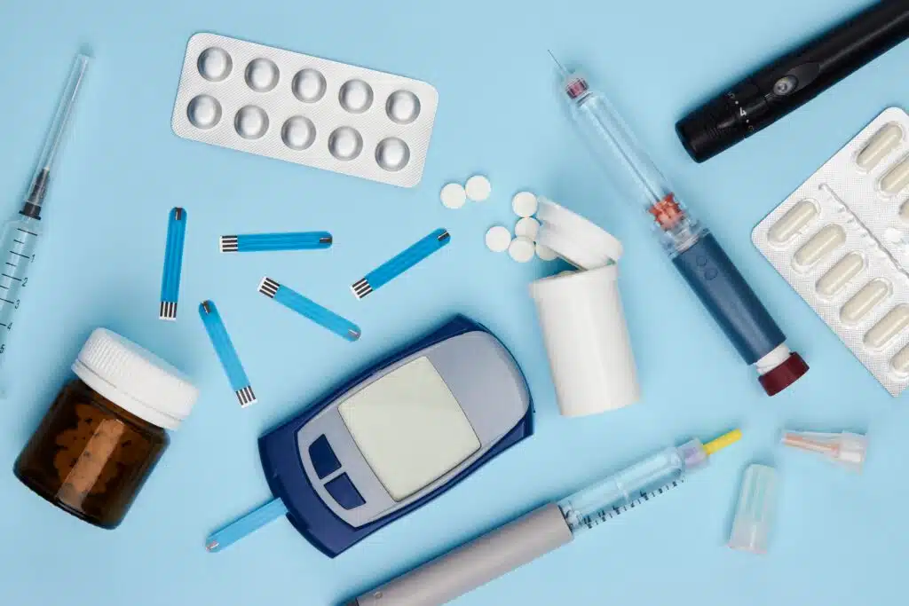 Medication and diabetes supplies on a light blue background